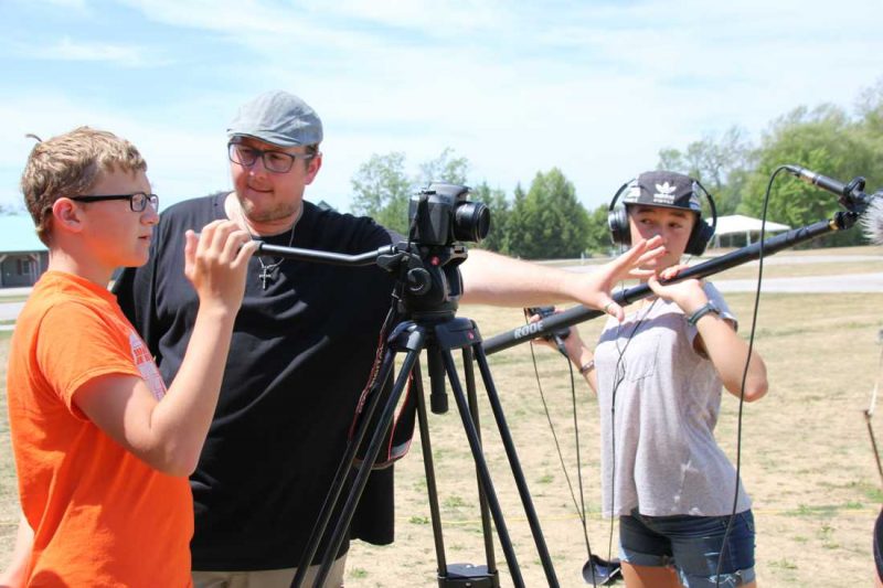 Film camp students around a camera