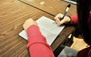 Person writing at desk